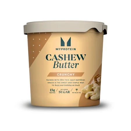 Een beige plastic kuipje met een lichtgrijze deksel, gevuld met Myprotein crunchy cashewboter.