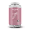 Een doorzichtige plastic pot met een roze etiket, gevuld met witte, ovale tabletten.