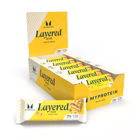 Een doos met Myprotein 'Witgoud' eiwitrepen, individueel verpakt in wit met gele wikkels.