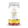 Een doorzichtige pot met witte deksel, gevuld met rode appelciderazijn gummies.