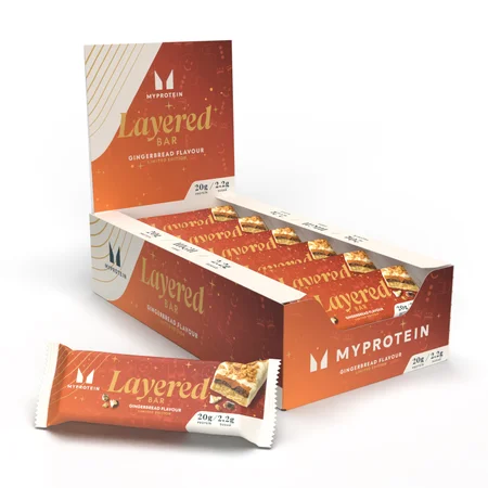 Een doos met Myprotein Layered Bar ontbijtkoek repen, met een losse reep ervoor.