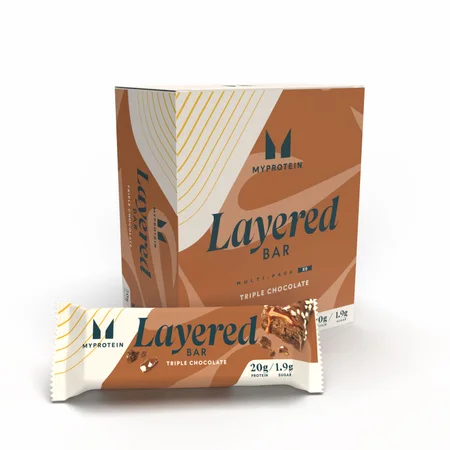 Een doos en een losse reep van Myprotein Layered Bar, triple chocolate smaak.