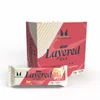 Een doos en een verpakte Myprotein Lean Layered Bar, wit met roze accenten.