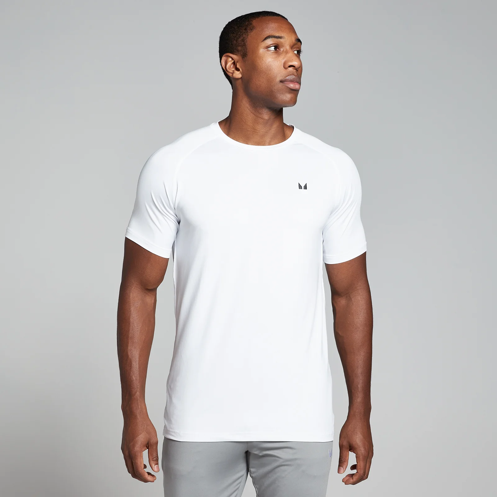 Een man draagt een wit MP trainingsshirt met korte mouwen en een klein logo.