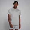Een man draagt een stormgrijs trainingsshirt met korte mouwen en bijpassende korte broek.