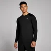 Een man draagt een zwart trainingsshirt met lange mouwen en een klein wit logo.