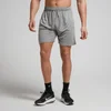Een man draagt een stormgrijze, korte trainingsbroek met een elastische tailleband en een trekkoord.