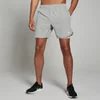 Een man draagt een stormgrijze MP 2-in-1 trainingsshort, met een elastische tailleband en een wit logo.