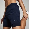 Een marineblauwe 2-in-1 trainingsshort voor heren met een elastische tailleband en een wit logo.
