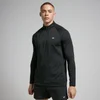 Een man draagt een zwarte trainingsoutfit met lange mouwen en een korte broek.