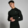 Een man draagt een zwart, nauwsluitend trainingsshirt met lange mouwen en een hoge hals.