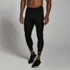 Een man draagt een zwarte, driekwart trainingslegging met een klein wit logo op de kuit.