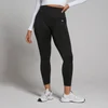 Een vrouw draagt een zwarte, naadloze 7/8 legging met een hoge taille en een klein logo.
