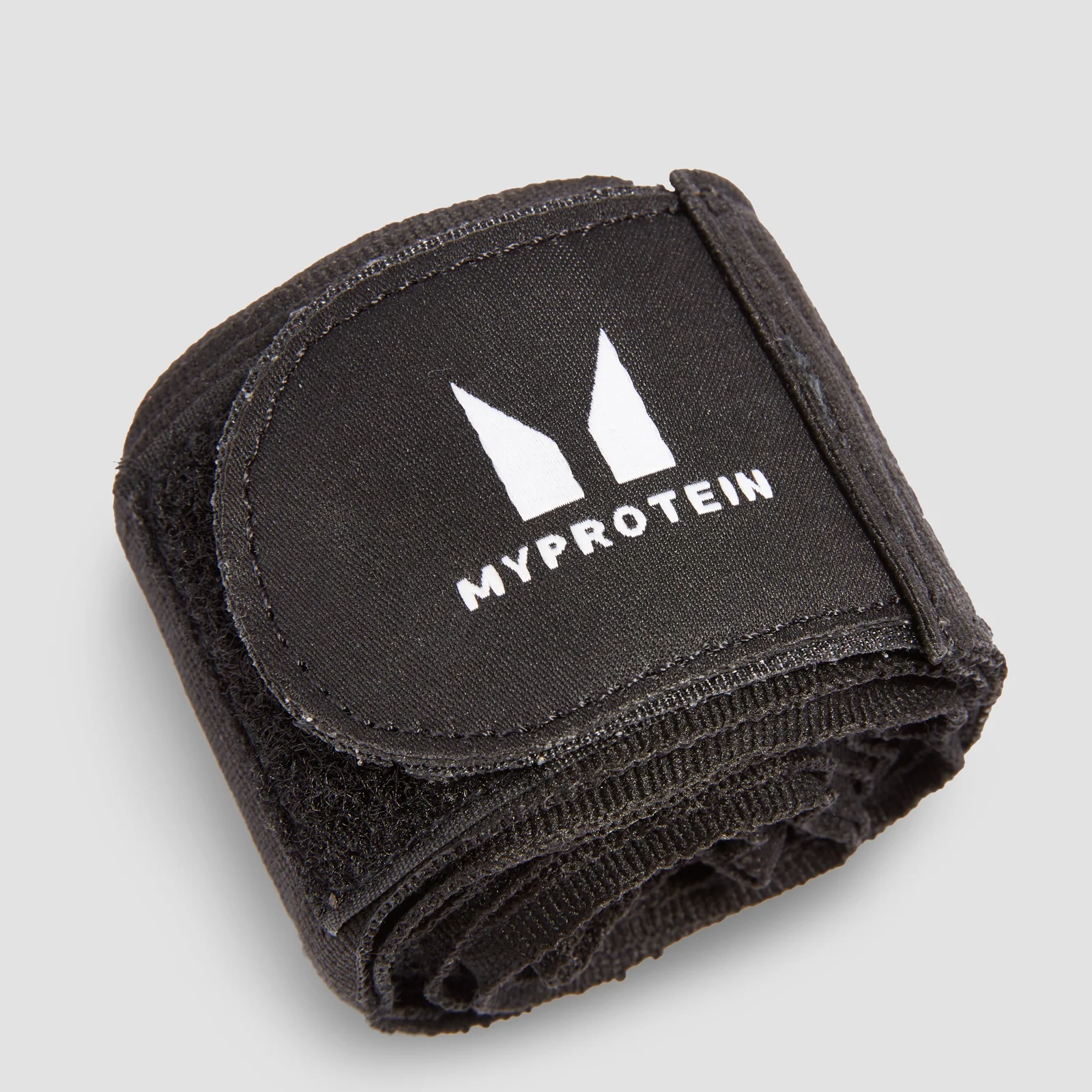 Een opgerolde, zwarte handbandage met het witte 'Myprotein' logo op een zwart label.