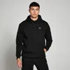 Een man draagt een zwarte hoodie met een wit logo en een zak aan de voorkant.