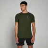 Een man draagt een gemêleerd legergroen T-shirt met korte mouwen en een klein wit logo.