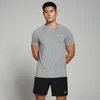 Een man draagt een grijs gemêleerd T-shirt met korte mouwen en zwarte shorts.