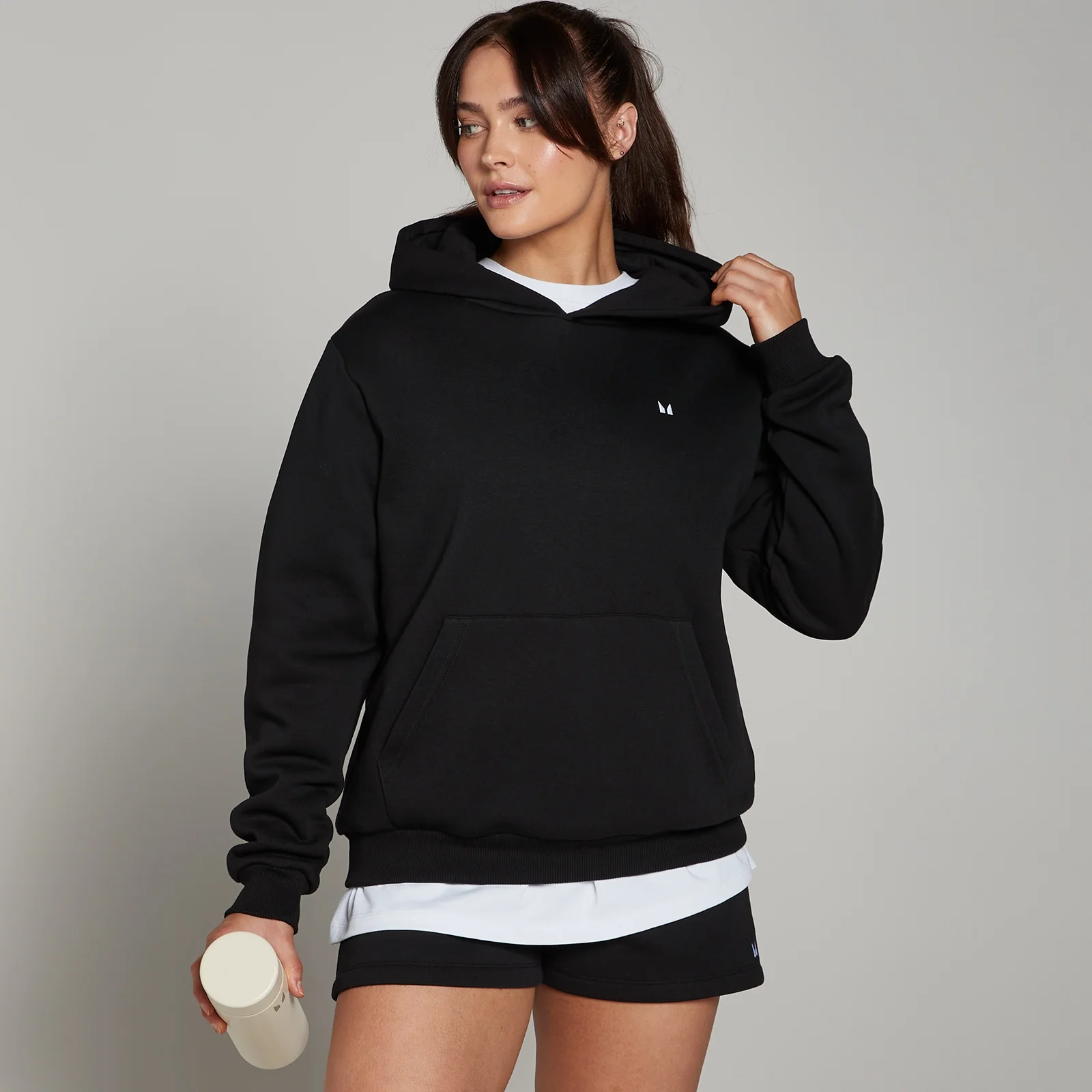 Een zwarte MP hoodie met capuchon en een buidelzak, gedragen door een vrouw.