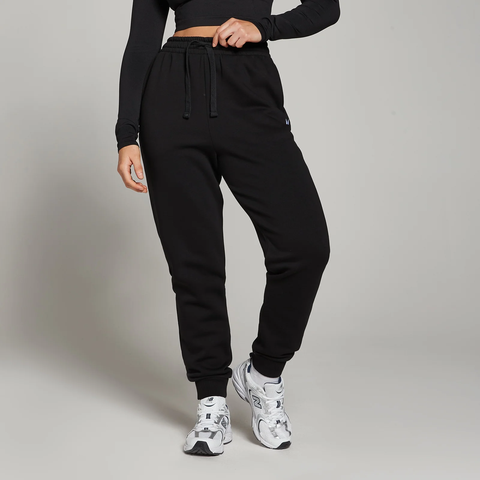 Een zwarte MP joggingbroek met trekkoord, gedragen door een model met een bijpassende top.