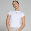 Een vrouw draagt een wit, nauwsluitend T-shirt met korte mouwen en een klein zwart logo.