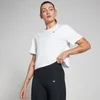 Een vrouw draagt een witte, losse croptop met korte mouwen en een klein MP logo.