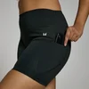 Zwarte fietsshort met hoge taille en een zak waar een telefoon in zit.