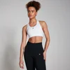Een vrouw draagt een witte sportbeha met racerback en zwarte legging.