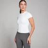 Een witte, nauwsluitende MP T-shirt met korte mouwen, gedragen met grijze leggings.