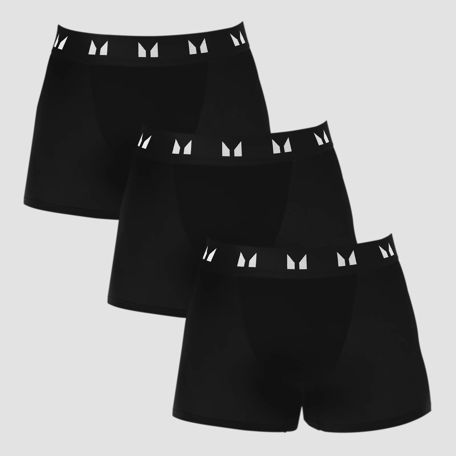 Drie zwarte boxershorts met een witte band met logo, gestapeld op elkaar.