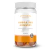 Een doorzichtige pot met witte deksel, gevuld met perzikkleurige gummies van het merk Myvitamins.