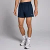 Een man draagt marineblauwe, korte sportbroeken met een elastische tailleband en witte sokken met sportschoenen.