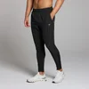 Een man draagt een zwarte MP trainingsjoggingbroek met een elastische tailleband en zakken.
