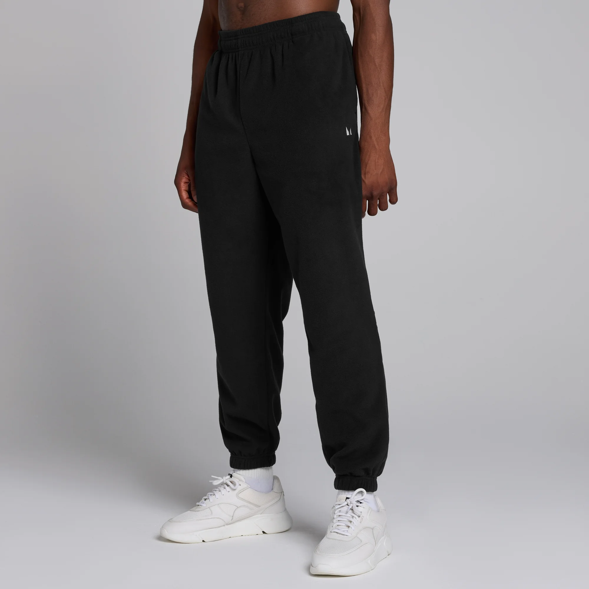 Een man draagt een zwarte MP joggingbroek met elastische tailleband en manchetten.