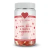 Een doorzichtige pot met een witte deksel, gevuld met rode en witte hartvormige gummies.
