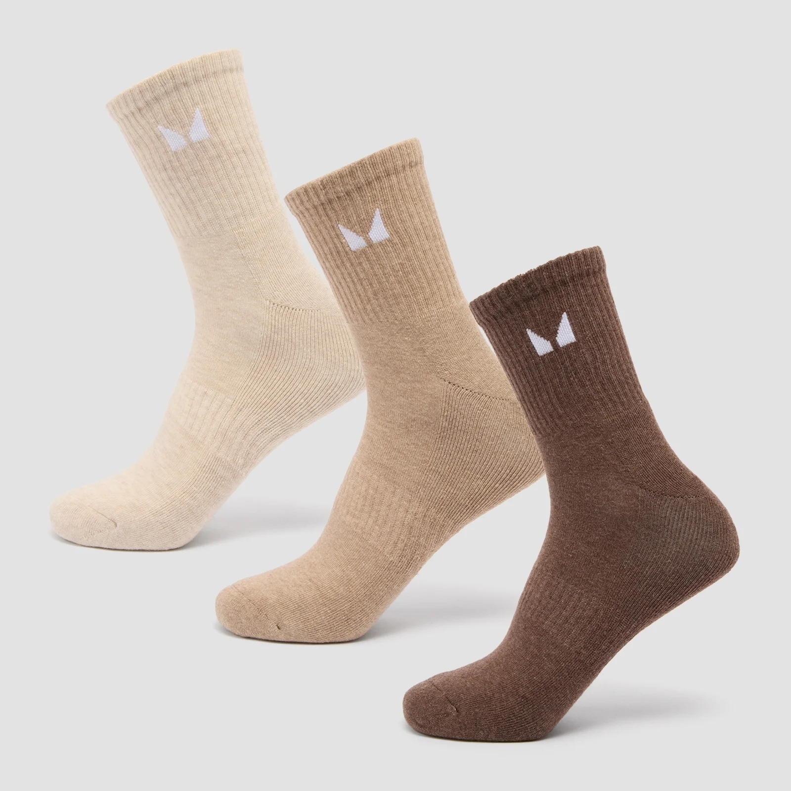Drie paar sokken in neutrale kleuren: beige, lichtbruin en bruin, met een wit logo.