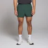 Een man draagt een donkergroene korte broek, witte sokken en witte sportschoenen.