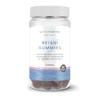 Een potje Myvitamins gummies met gesteelde lakzwam, gevuld met donker gekleurde snoepjes.