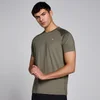 Een man draagt een olijfgroen trainingsshirt met korte mouwen en een klein logo.