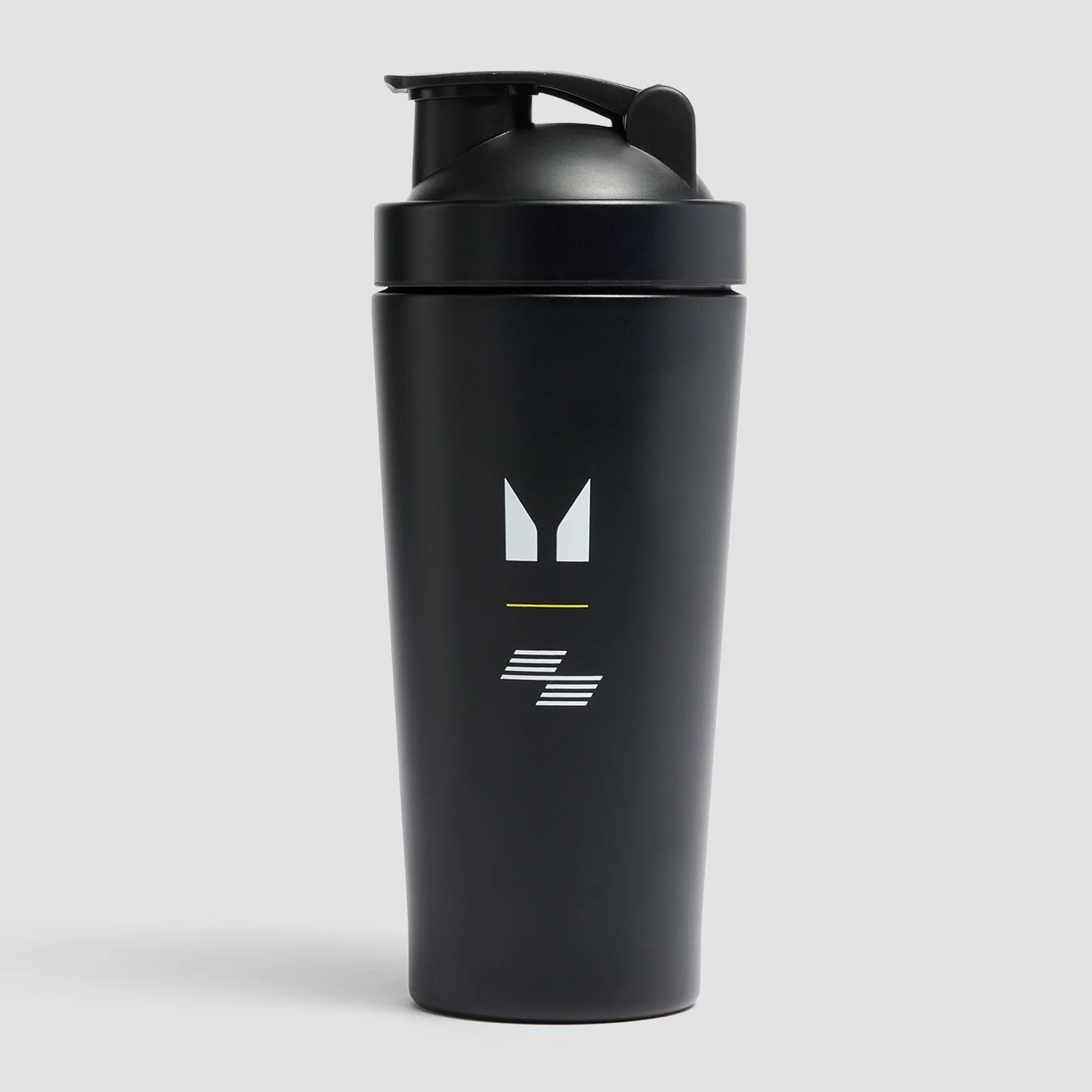 Zwarte Myprotein shaker met logo en zwarte dop, staand op een grijze achtergrond.
