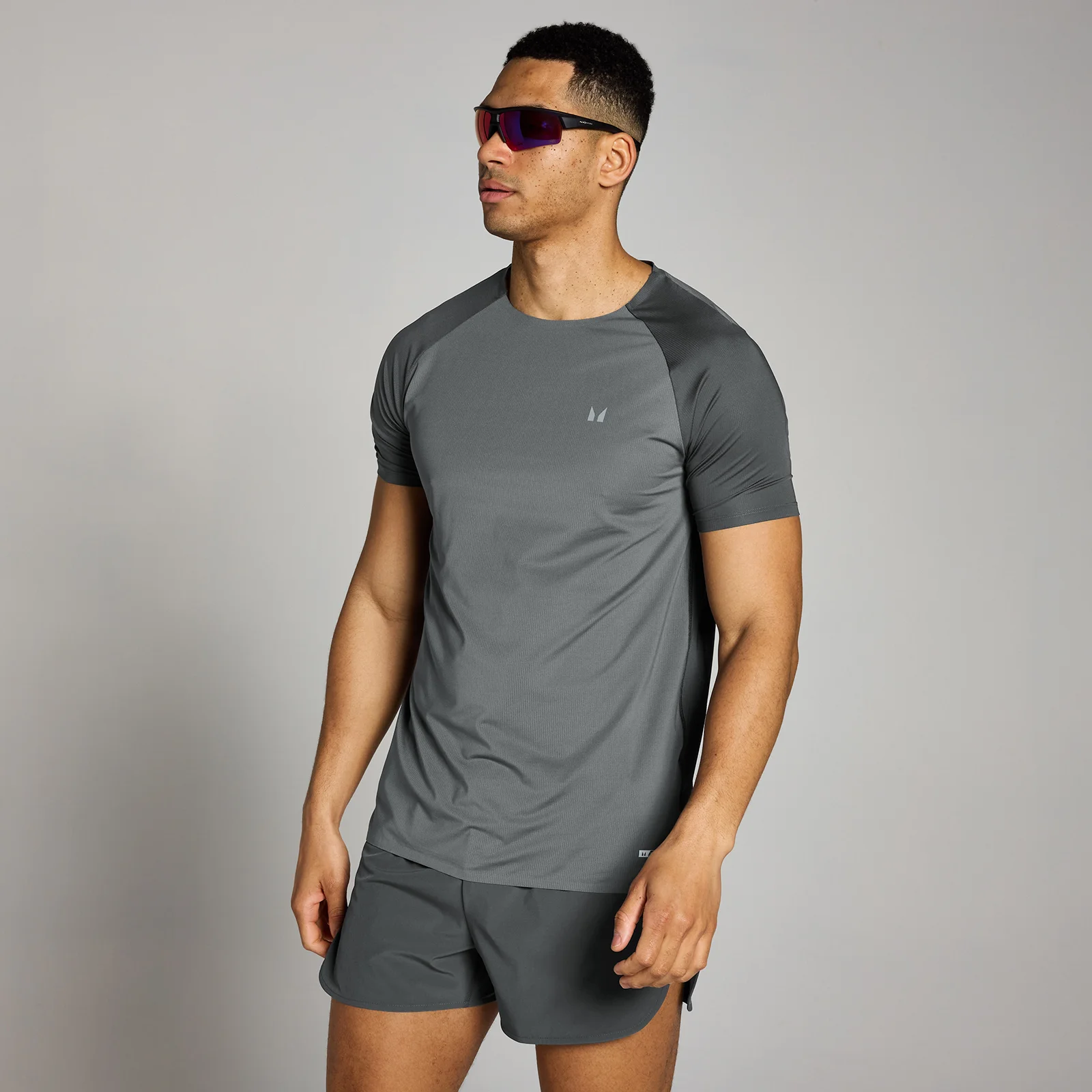 Een donkergrijs MP T-shirt met korte mouwen en een klein logo, gedragen met bijpassende korte broek.