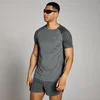 Een donkergrijs MP T-shirt met korte mouwen en een klein logo, gedragen met bijpassende korte broek.
