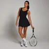 Een vrouw draagt een zwarte, mouwloze tennisjurk en houdt een tennisracket vast.