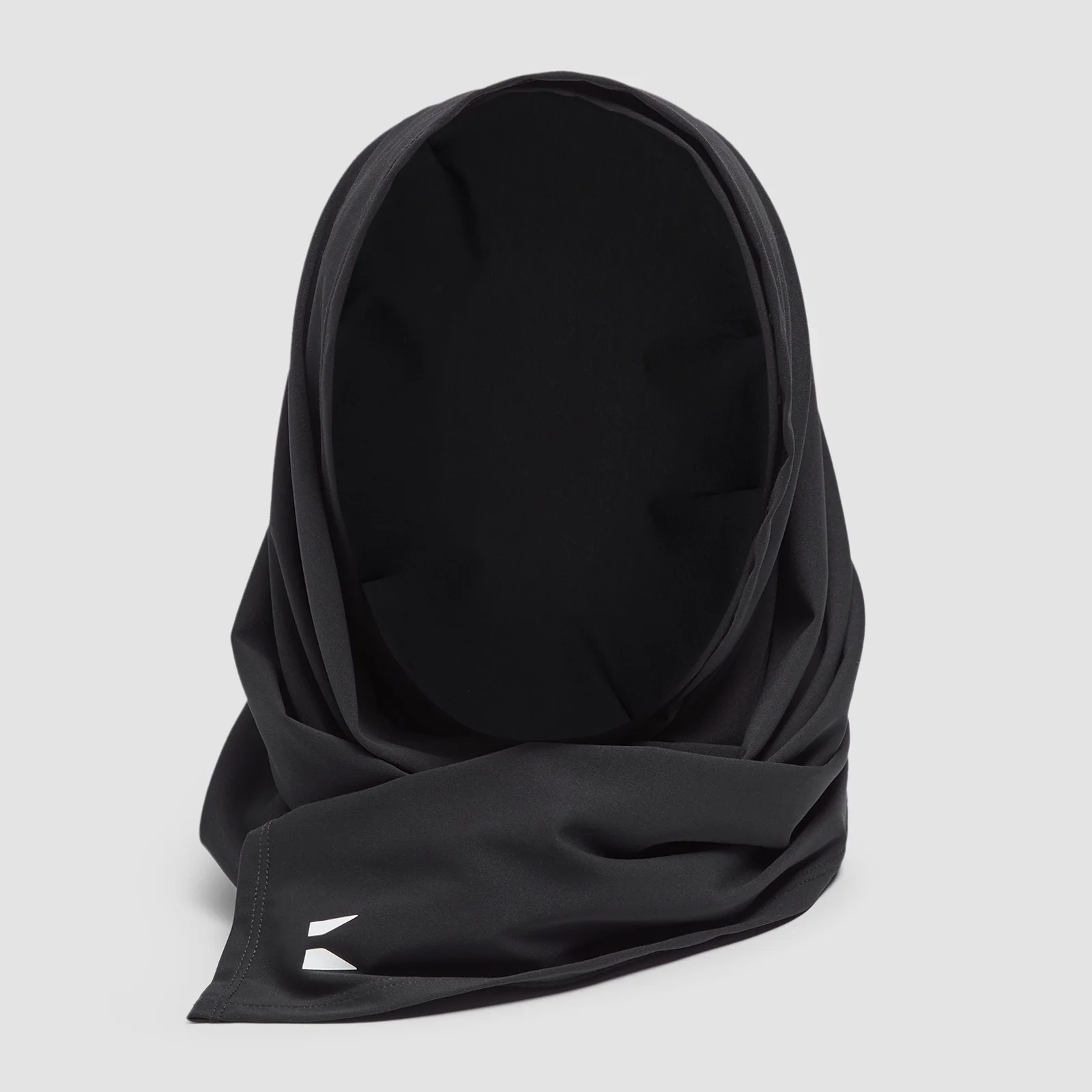Een zwarte MP hijab, gemaakt van gladde stof, met een klein wit logo.