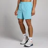 Een man draagt cyaanblauwe MP Tempo shorts met een elastische tailleband en witte sokken met sportschoenen.