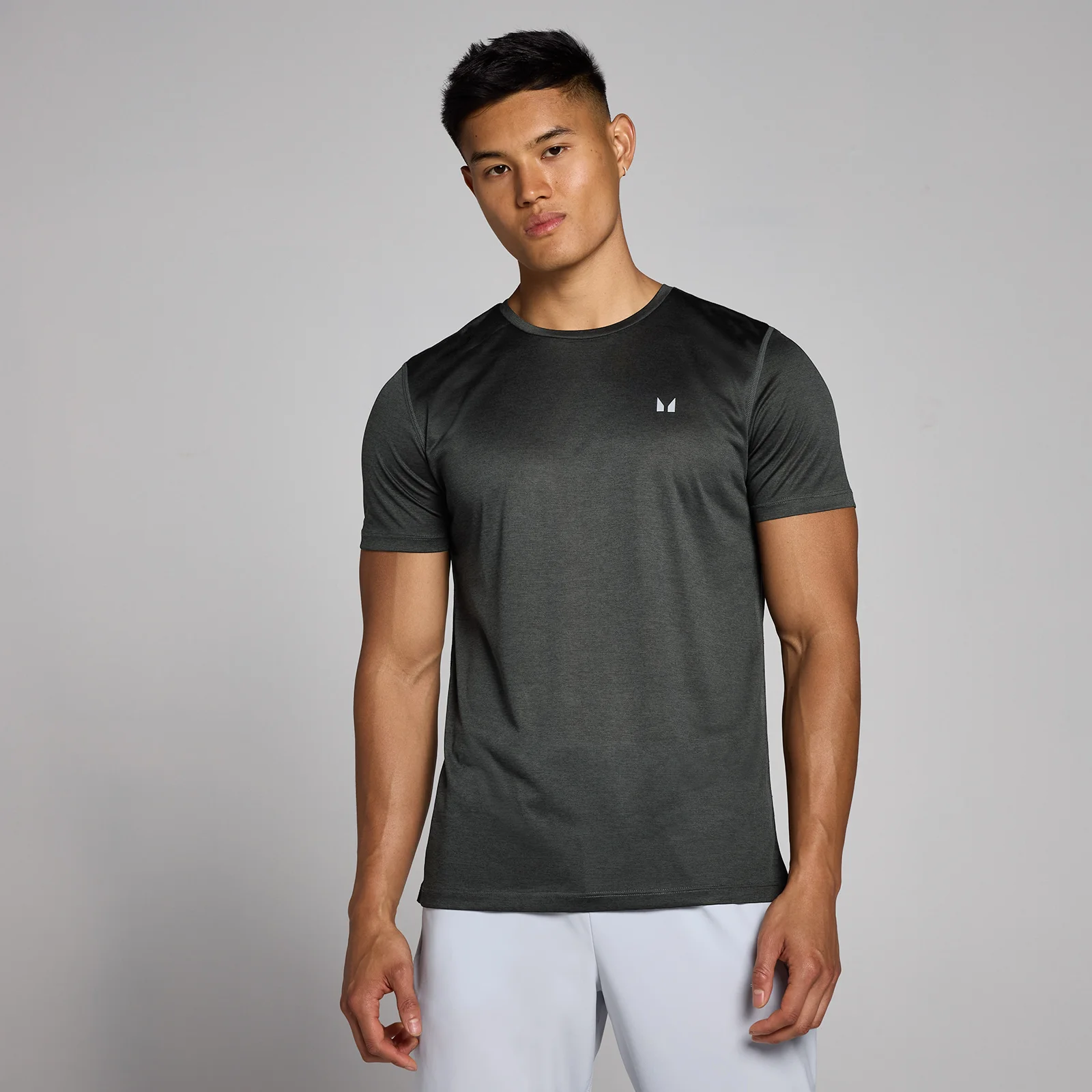 Een gemêleerd zwart T-shirt met korte mouwen en een klein wit logo.