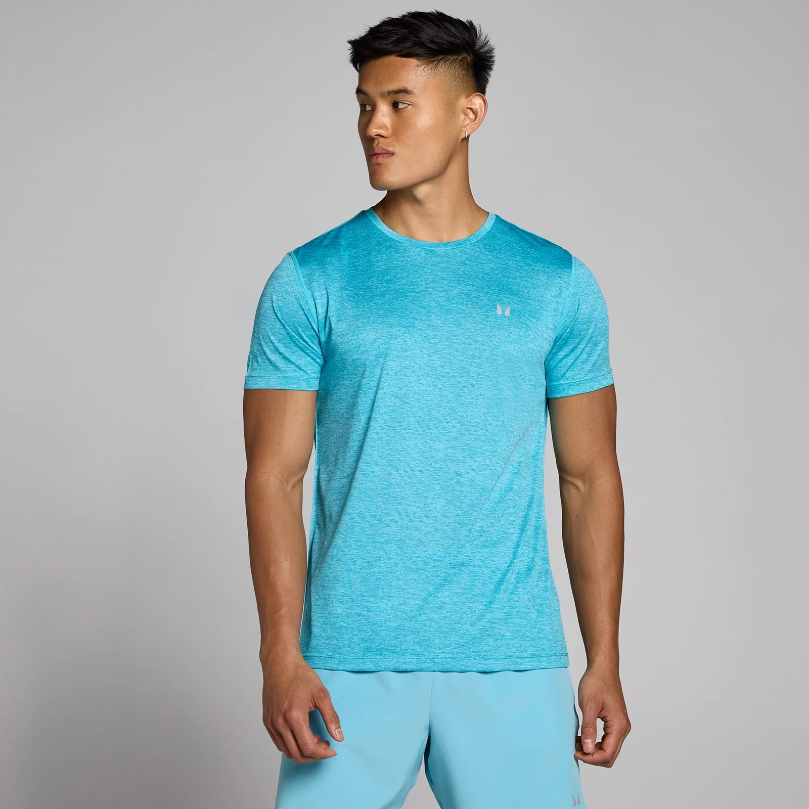 Een cyaan gemêleerd T-shirt met korte mouwen en een klein logo op de borst.
