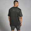 Een man draagt een nachtgrijs, oversized trainingsshirt met korte mouwen en een MP logo op de rug.
