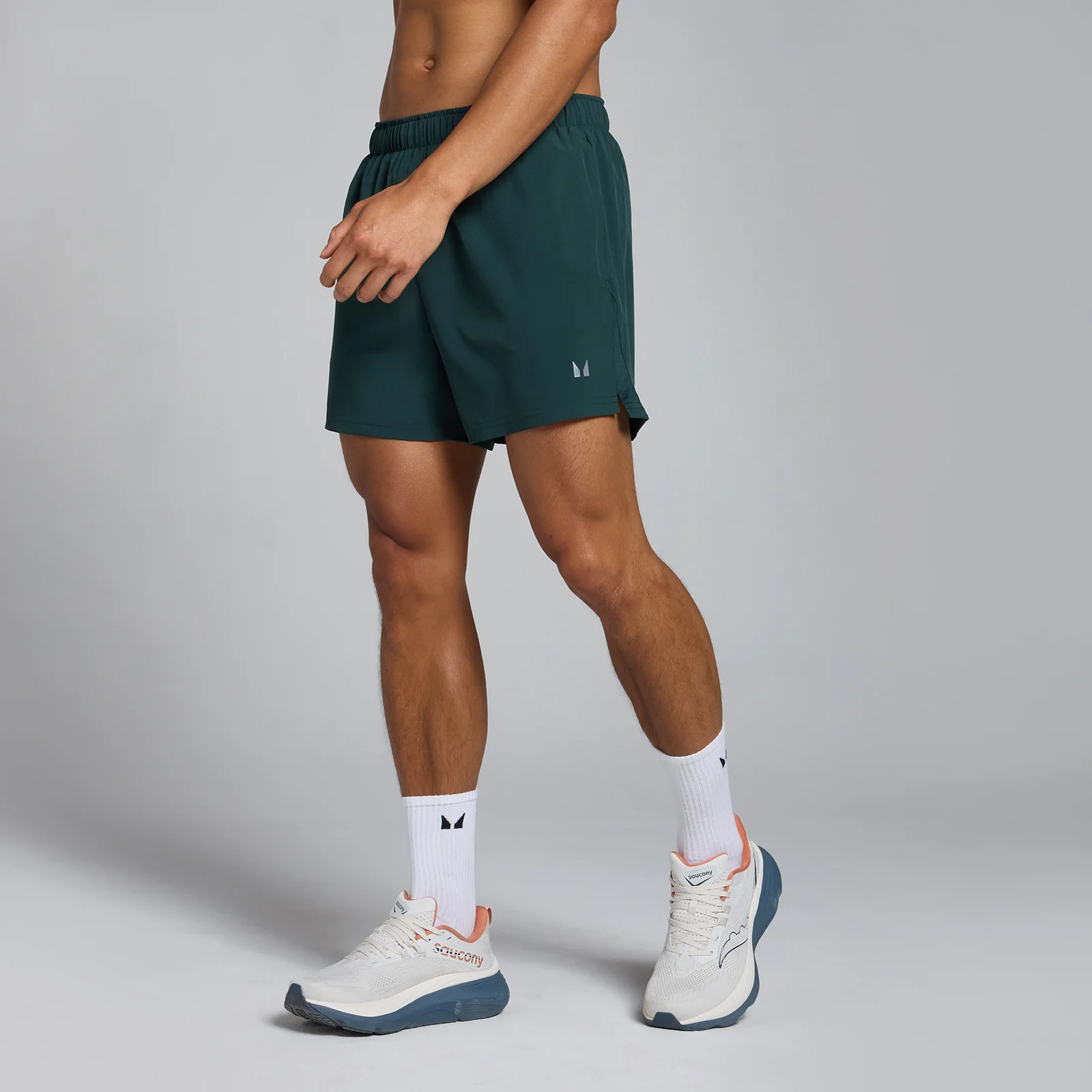 Een man draagt een donkergroene MP Tempo short met witte sokken en sportschoenen.