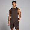 Een man draagt een chocoladebruin hemd zonder mouwen en bijpassende korte broek met een klein wit logo.