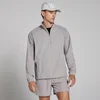 Een man draagt een paddenstoelenbruin MP lichtgewicht windjack met korte broek en een pet.